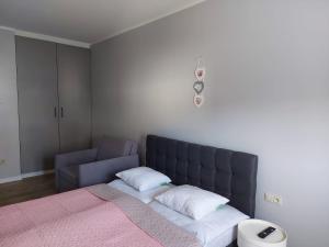 a bedroom with a large bed with a pink blanket at Apartamenty z tarasami "Miętowy spokój 15" "Romantyczna szarość 16" "Niebieska elegancja 17" maksymalnie dla 6 osób in Pobierowo +28 photos