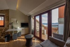 - un salon avec un canapé et une grande fenêtre dans l'établissement Apartamentos Praia do Capitàn, à Muxía