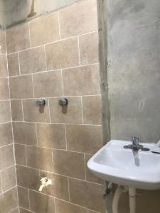 カンペチェにあるDepartamento sencillo en CAMPECHE EX HACIENDA KALAのタイル張りの壁、洗面台付きのバスルーム