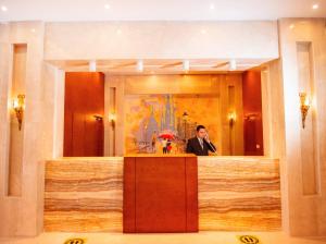 a man standing behind a podium in a hotel lobby at Lamar Azur Hotel in Dumyāţ al Jadīdah