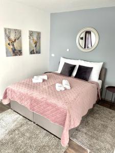 a bedroom with a pink bed with two towels on it at D&A Apartment with private swimming pool in Pula