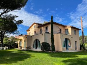 a large white house with a grass yard at Villa Angelina Garden in Grimaud