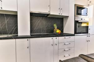 une cuisine avec des armoires blanches et un comptoir en ananas dans l'établissement Luxury Korda apartments 011, à Budva