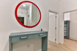 een badkamer met een blauwe dressoir en een rode spiegel bij Luxury Korda apartments 011 in Budva