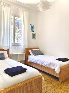 1 dormitorio con 2 camas y ventana en Da u Franchin en Carloforte