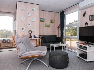 un salon avec une chaise et une télévision dans l'établissement 6 person holiday home in Fan, à Fanø