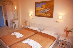 a hotel room with two beds and a painting on the wall at St.George Valsamitis in Katapola