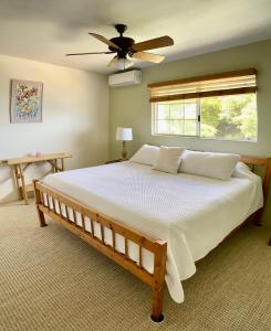 a bedroom with a large bed with a ceiling fan at The Great Kona Escape in Kailua-Kona