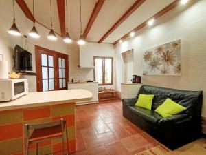 a living room with a black leather couch and a kitchen at Apartamento Aymara de StarApsTenerife in Sauzal