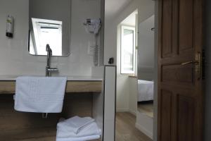La salle de bains est pourvue d'un lavabo et d'un miroir. dans l'établissement Logis Hôtel Etchemaïté, à Larrau