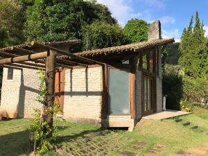 マレシャウ・フロリアノにあるPousada Rocamadourの草の中にドアを持つ小さな木造の建物