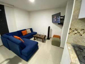 sala de estar con sofá azul y TV en Apartamento Villavicencio Elegante, en Villavicencio