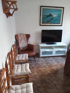 a living room with a tv and a chair at Ca Pepet in Adzaneta de Albaida