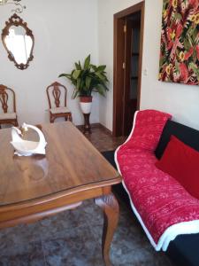 a living room with a table and a red couch at Ca Pepet in Adzaneta de Albaida
