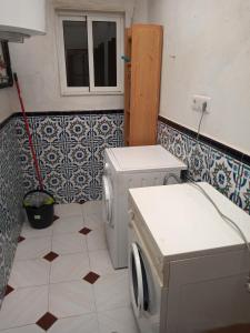 baño con lavadora y ventana en Ca Pepet, en Adzaneta de Albaida
