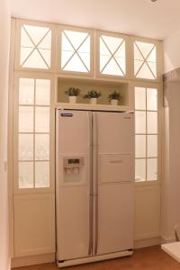 a white refrigerator in a room with windows at 4 Cantos in Faro