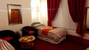 Habitación con 1 cama, 2 sillas y mesa. en Broomlea Guest House, en Dyce