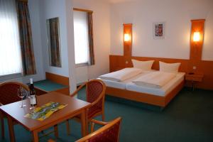 Hotel zur Post في باشاراش: غرفة فندقية بسرير وطاولة وكراسي