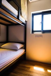 1 dormitorio con 2 literas y ventana en 台灣潛水綠島店 Green Island Dive en Green Island