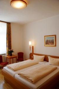Hotel zur Post في باشاراش: غرفة فندقية بسريرين وطاولة