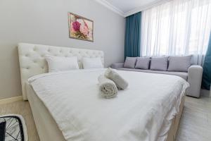 a bedroom with a large white bed with two pillows at Happy House in Taldykolʼ