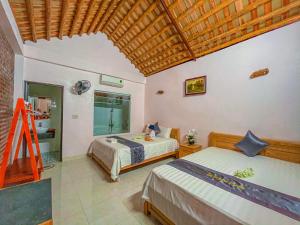a bedroom with two beds and a wooden ceiling at Tam Coc Sunrise Homestay in Ninh Binh +29 photos