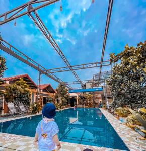a little boy standing in front of a swimming pool at Tam Coc Sunrise Homestay in Ninh Binh