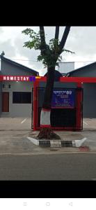 un albero di fronte a un distributore di benzina con un edificio di Homestay 89 New a Jepara