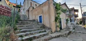 a set of stairs with a blue door on a building at Traditional Hillside Cottage in Gythio
