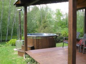 ein Whirlpool auf einer Holzterrasse mit einem Pavillon in der Unterkunft Latava in Anykščiai + 15 Fotos