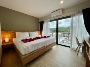 una camera da letto con un letto con rose rosse di Room Actually Service Apartment a Karon Beach