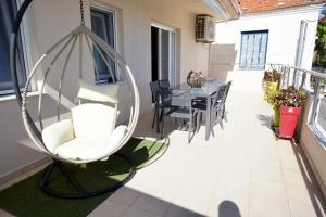 a swing on a balcony with a table and chairs at Casa Ideale in Limenaria
