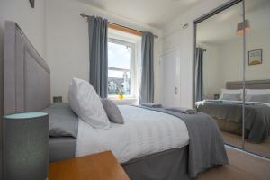 ein Schlafzimmer mit einem großen Bett und einem Spiegel in der Unterkunft Dwellcome Home Ltd 1 Bed Aberdeen Apartment - see our site for assurance in Aberdeen