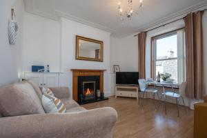 ein Wohnzimmer mit einem Sofa und einem Kamin in der Unterkunft Dwellcome Home Ltd 1 Bed Aberdeen Apartment - see our site for assurance in Aberdeen