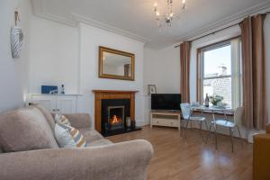 a living room with a couch and a fireplace at Dwellcome Home Ltd 1 Bed Aberdeen Apartment - see our site for assurance in Aberdeen