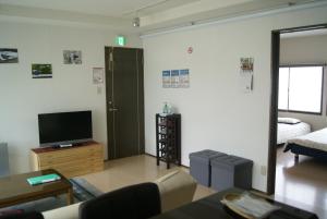 a living room with a couch and a tv in it at IZARI Village in Eniwa