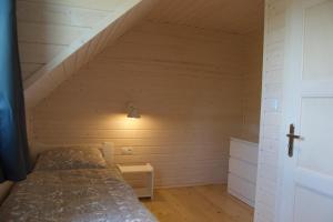 a bedroom with a bed in a attic at Aurora - Domki całoroczne nad morzem w Dziwnówku in Dziwnówek +11 photos
