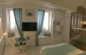 a living room with a tv and a couch and a chair at Stone studio in Saint-Tropez