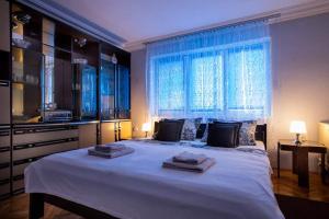 um quarto com uma grande cama branca com janela em Isabel em Palić