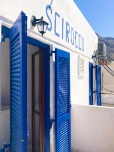 
a blue and white building with a blue door at Scirocco Rooms in Loutro
