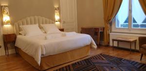 - une chambre avec un grand lit blanc et une fenêtre dans l'établissement LA MAISON LEONARD, à Bléré