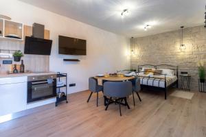 een keuken en een woonkamer met een tafel en een bank bij TEONA Luxury Studio Apartment with jacuzzi and terrace sea view in Sali