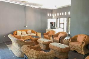 ein Wohnzimmer mit Korbstühlen und Sofas in der Unterkunft Taman Wisata Siwalk Cottage Syariah RedPartner in Cirebon