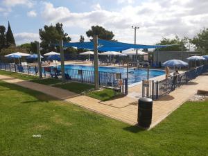 a swimming pool with umbrellas and a swimming poolintendent at יעלה בנוף ראש פינה in Rosh Pinna