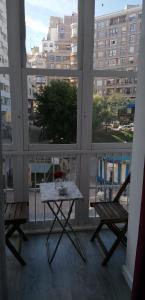 stół i 2 krzesła na balkonie z oknem w obiekcie Pisazo calle Peatonal en el centro! w mieście Santander