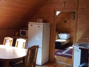 Zimmer mit einem Kühlschrank und einem Tisch in einer Hütte in der Unterkunft Gospodarstwo Agroturystyczne Aniela in Piecki