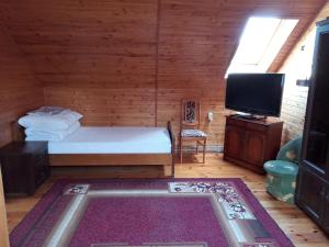 a bedroom with a bed and a flat screen tv at Gospodarstwo Agroturystyczne Aniela in Piecki