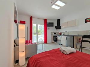 um quarto com uma cama vermelha e uma cozinha em Fantastico em Puerto de la Cruz