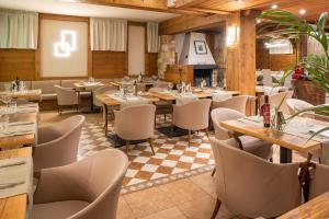 a restaurant with tables and chairs in a room at Golf Cà Degli Ulivi in Costermano