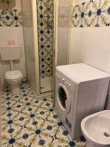 een badkamer met een wasmachine en een toilet bij Casa stile mediterraneo Piazza Durante a Letojanni Taormina in Letojanni
